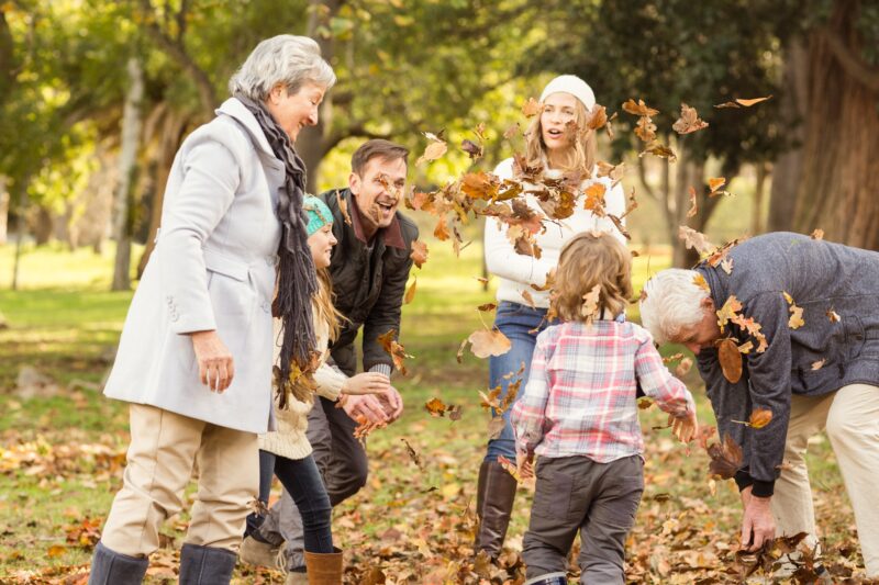 Family playing in park with leaves